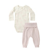 Baby outfit set with cream long-sleeve top and pink pants on a white background
