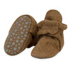 Brown baby booties with textured sole on a white background