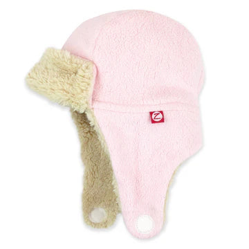 Pink knit baby hat with beige earflaps on a white background